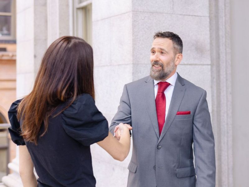 John Montagna smiling shaking hands with a personal injury client after a successful case result