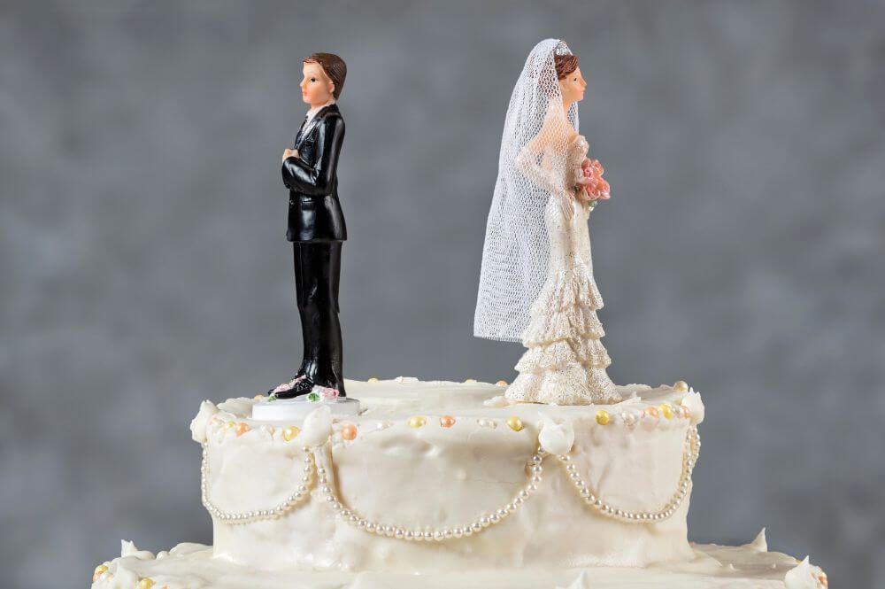 bride and groom wedding cake toppers facing opposite directions