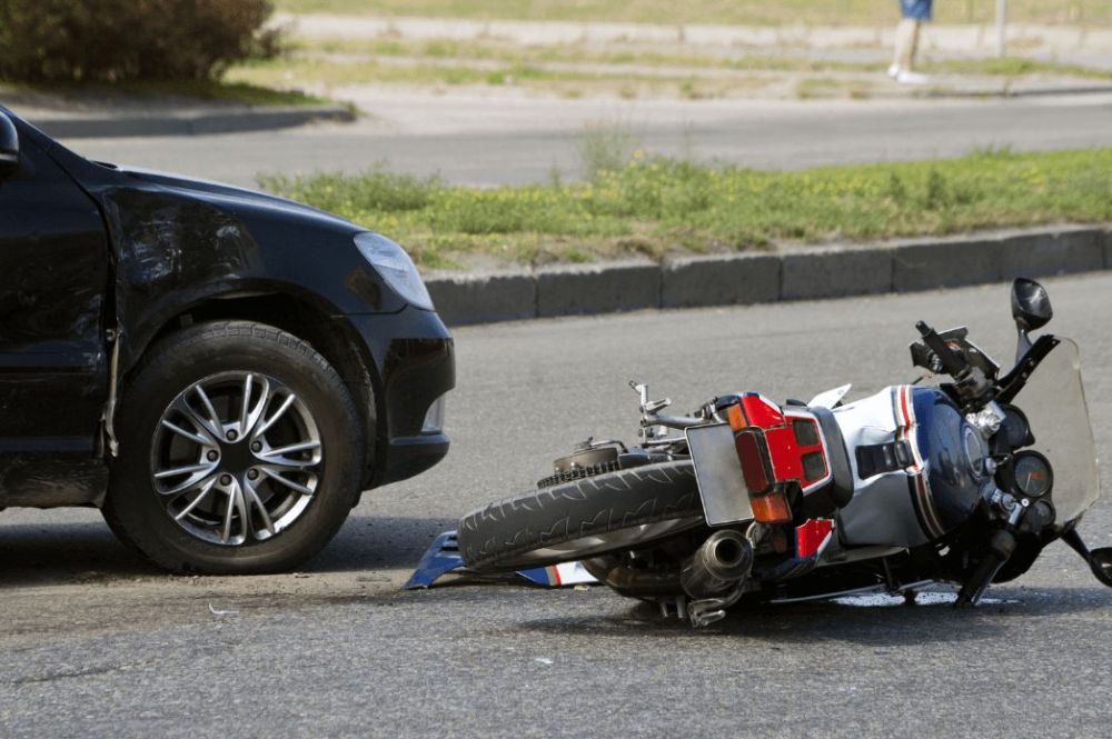 motorcycle on its side after accident with car