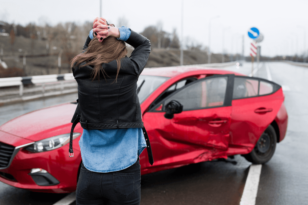 Woman looking at her wrecked car