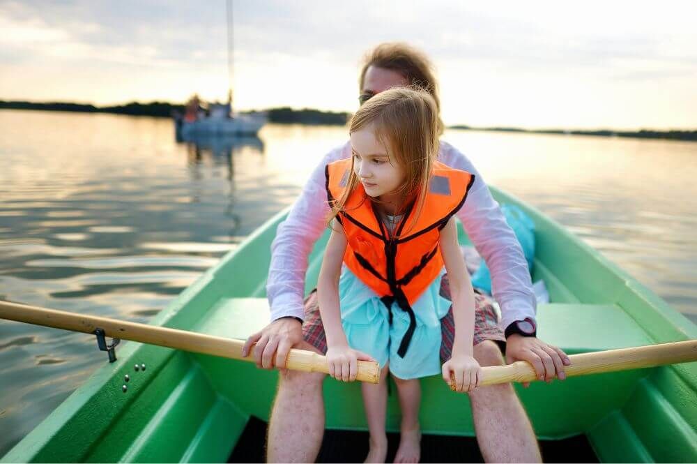 A father and daughter on a row boat together