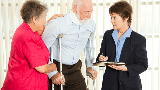 Elderly man using crutches and talking to a lawyer