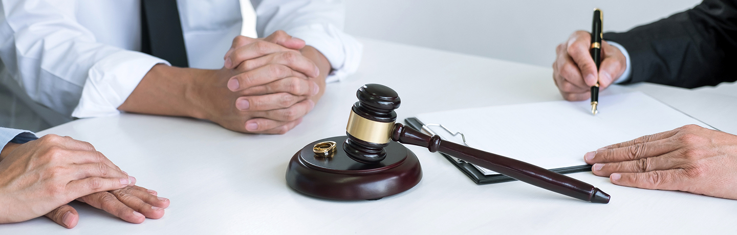 couple sitting down at a table with a lawyer writing on documents