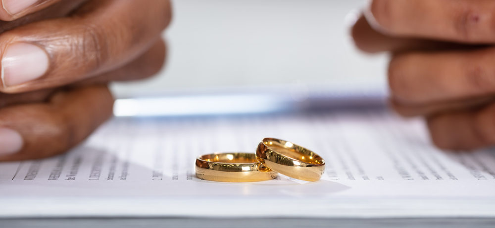 husband and wife's hands on divorce paper work