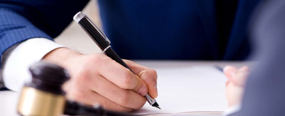 man sitting at a desk writing in a document