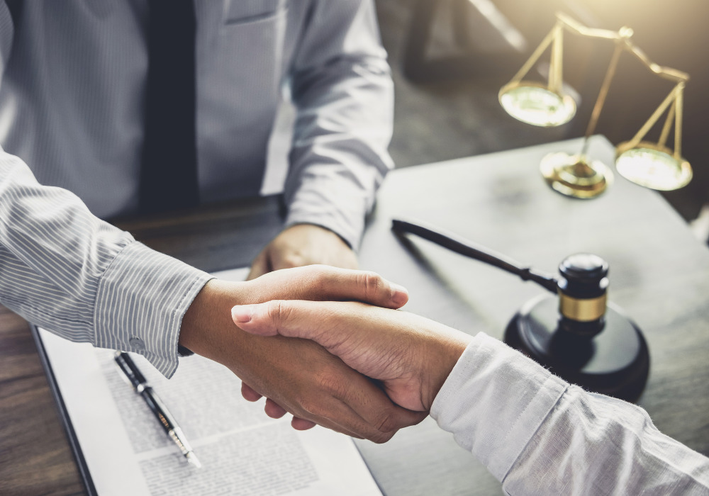 two men shaking hands at a desk