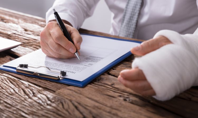 man signing document with cast on hand