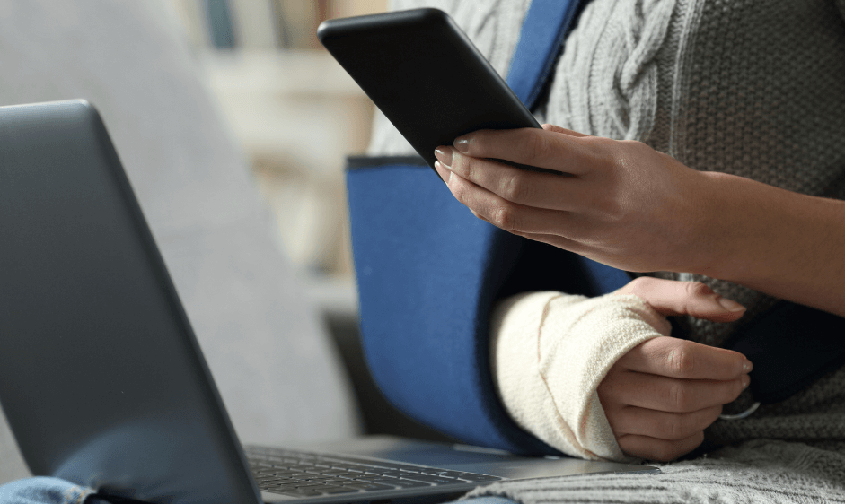 Man wearing an arm sling using his phone