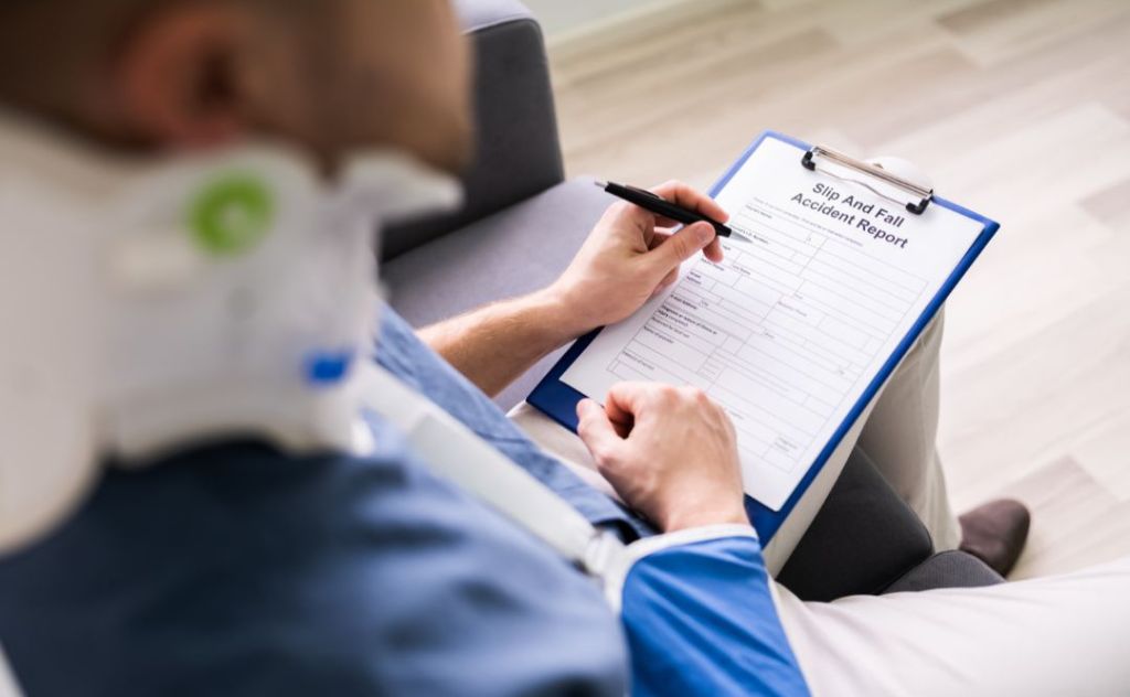 man wearing a neck-brace filling out an accident report