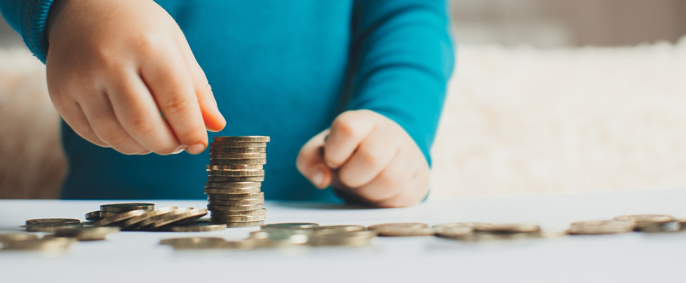 child stacking coins