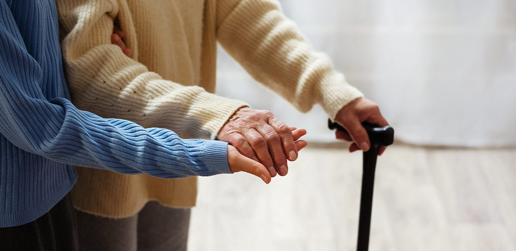 elderly woman being assisted with walking