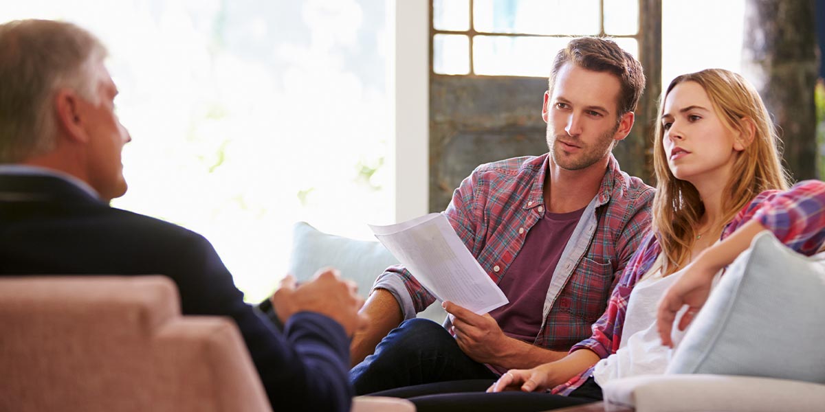 a father sitting across from his two adult children discussing estate planning