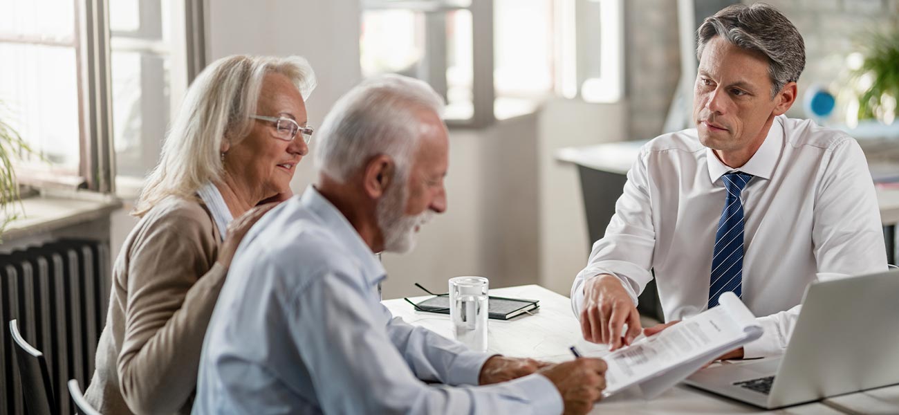 elderly couple reviewing a trust in front of a lawyer