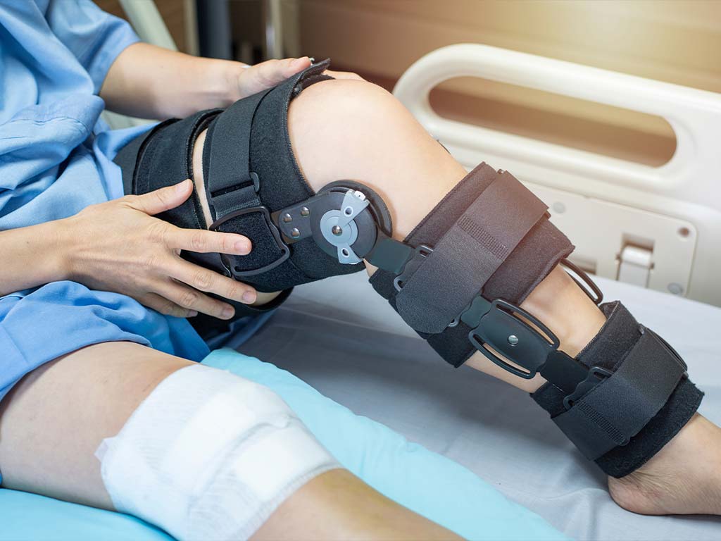 man wearing a leg brace after a leg injury