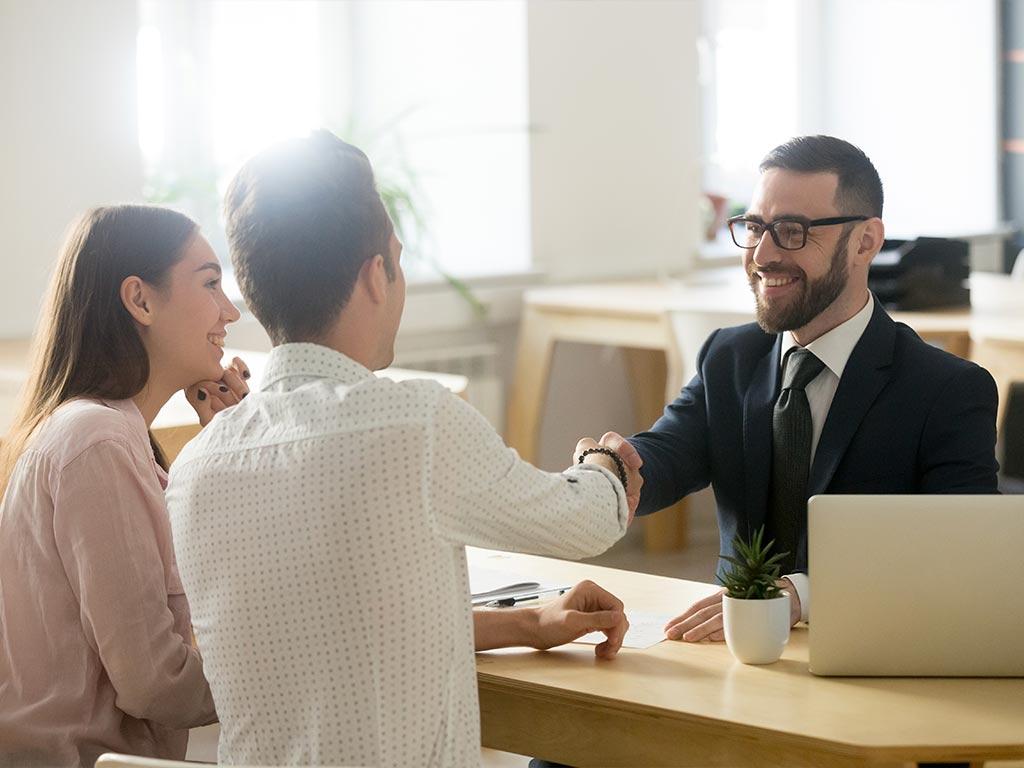 lawyer shaking hands with a man sitting next to his wife