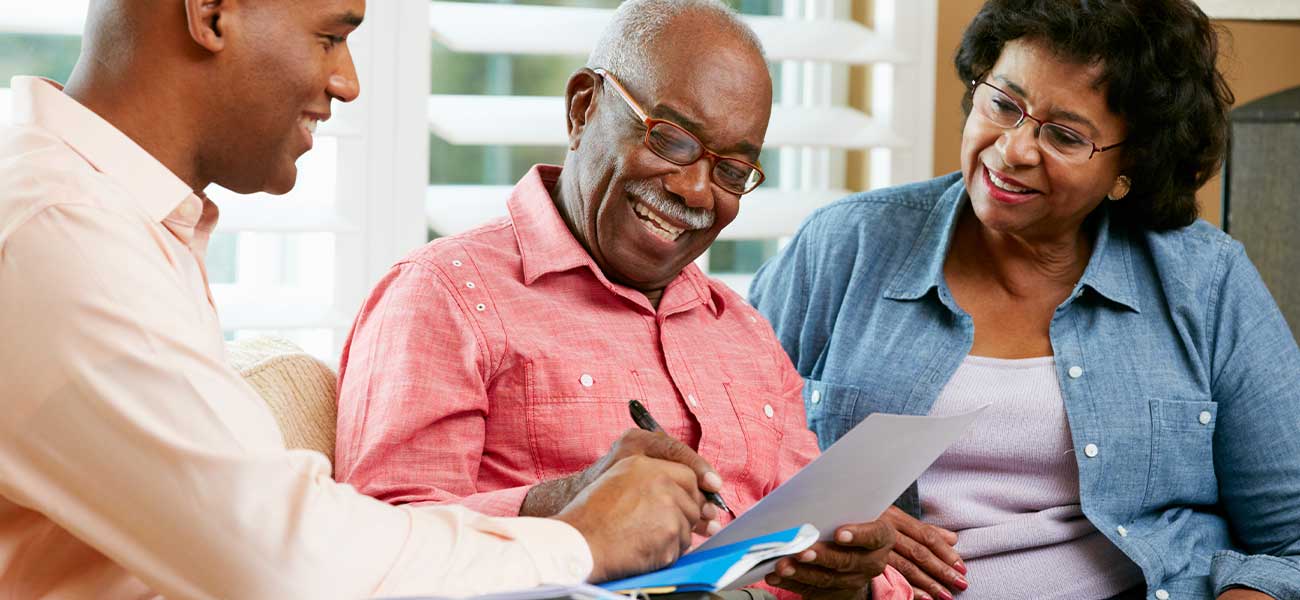 Elderly man and woman signing a will with a lawyer