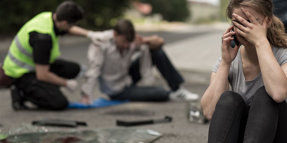 woman crying on the phone after being in a car accident