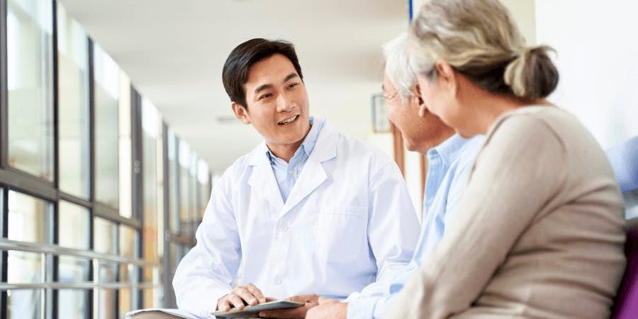 doctor talking to two older aged patients 