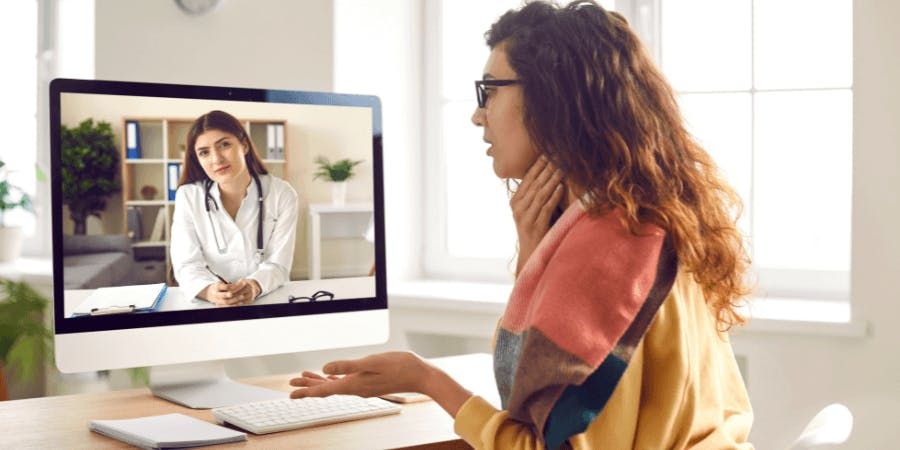 woman video chatting with doctor from her home office