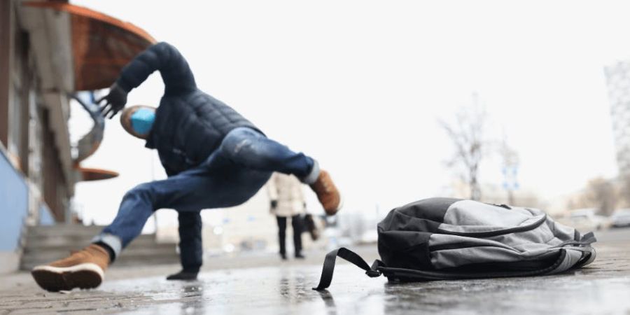 man slipping and falling on wet ground