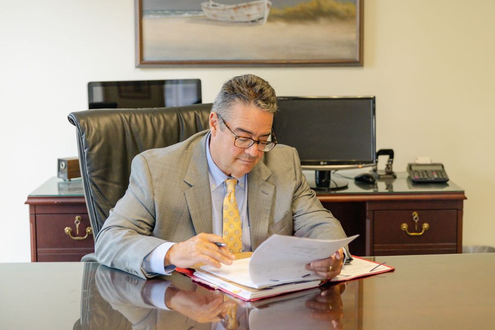 Lance Jackson, social security disability lawyer at Montagna Law reviewing paperwork on a large wooden desk