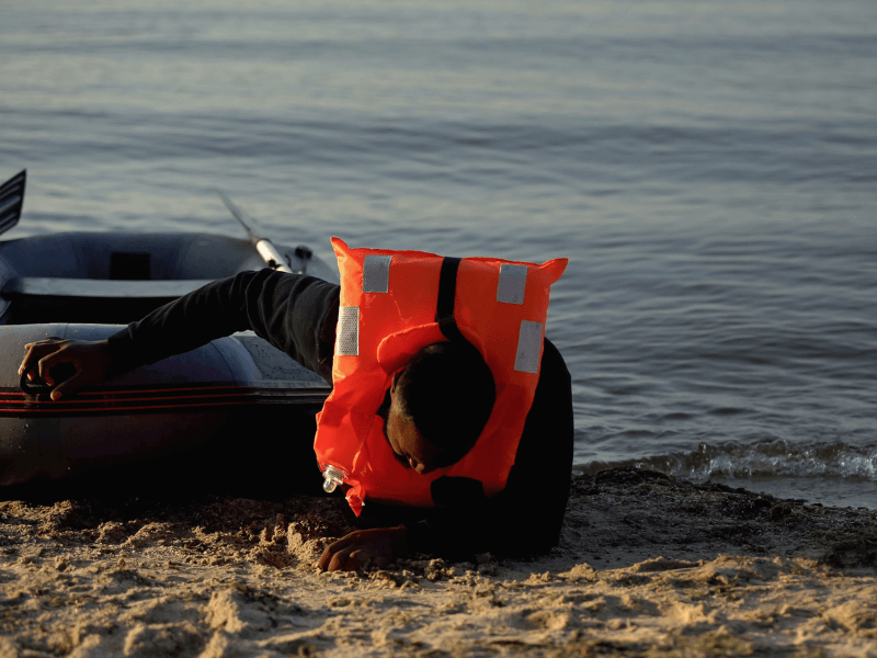 Sailor wearing a life preserver on the beach