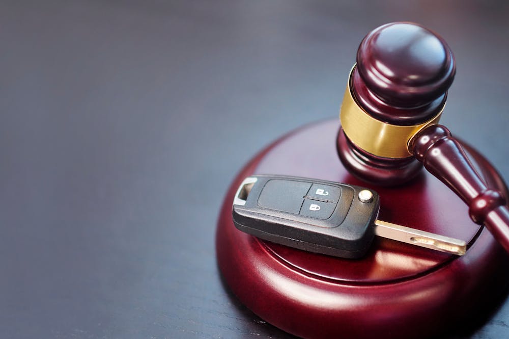 A key car and a gavel rest on a table, this implies law codes related to car accidents or issues.