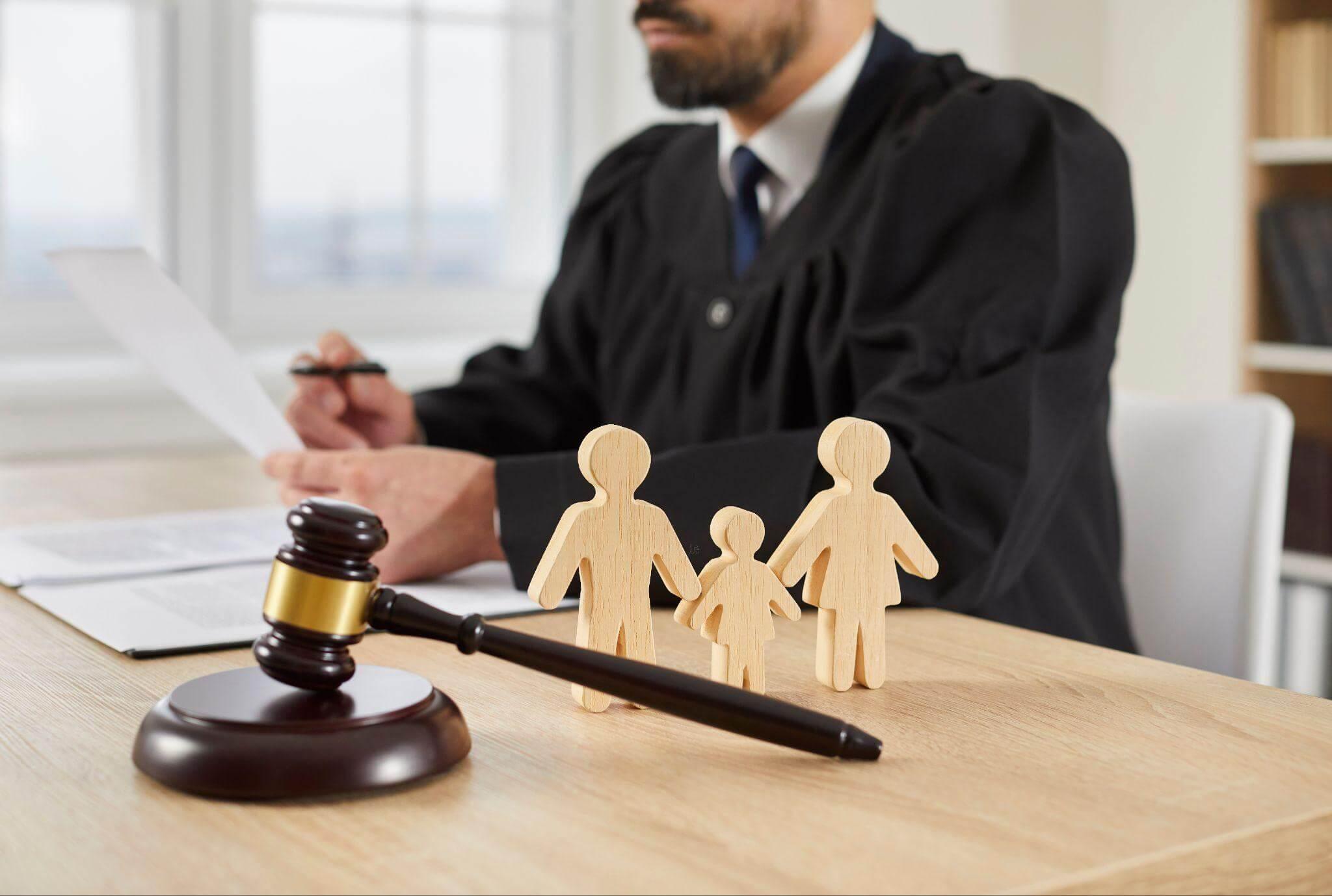Judge with wooden family figure demonstrating family law concept