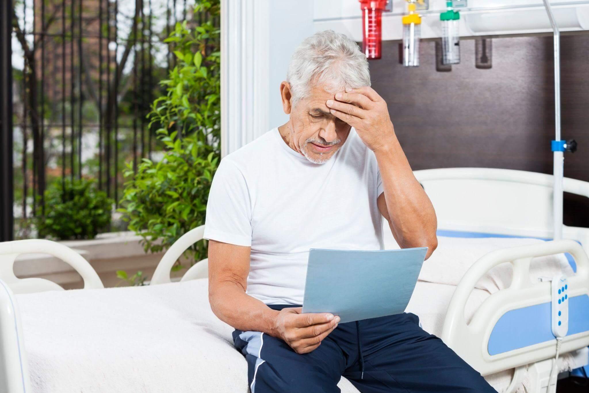 Man reviewing social security disability documents on hospital bed